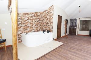 a white bath tub in a room with a stone wall at Caisae Eco-Lodge in San Antonio