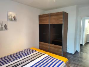 a bedroom with a bed and a large wooden cabinet at Nordsee Resort in Wangerland