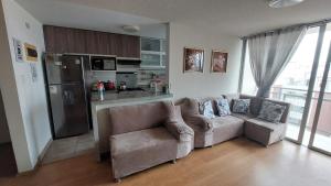 a living room with a couch and a kitchen at Apartamento Varela in Lima