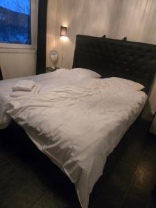 a large white bed with a black headboard in a bedroom at Takelvdal in Björklid