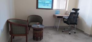 a room with a desk and a chair and a table at Kings Home Stay in Nakuru +4 photos
