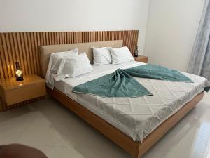 a bedroom with a bed with a green blanket on it at Salt & Sand T3 in Praia