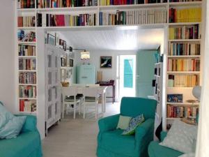 a living room with a green couch and book shelves at Lo Sceriffo delightful villa in dreamy garden AC in Monterosso al Mare