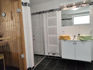 a bathroom with a shower and a sink at Nordsee Resort in Wangerland +12 photos