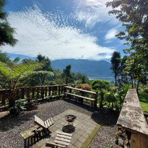a patio with two chairs and a bench and a fence at Bedugulhome in Bedugul