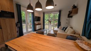 a living room with a table and a couch at Rustige natuur lodge bij Deventer met privé terras in Gorssel