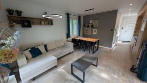 a living room with a couch and a table at Rustige natuur lodge bij Deventer met privé terras in Gorssel +5 photos