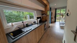 a kitchen with a sink and a window at Rustige natuur lodge bij Deventer met privé terras in Gorssel
