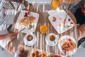 a group of people sitting at a table eating breakfast at Adama Mykonos Boutique Hotel in Mikonos +31 photos