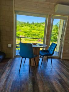 a room with a table and chairs and a large window at Славський Двір in Slavske