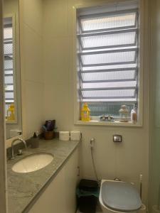 a bathroom with a sink and a toilet and a window at Copacabana Rooms & Hostel in Rio de Janeiro +50 photos