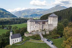 an old castle with cars parked in front of it at Alpinresort Kaprun 3 in Kaprun