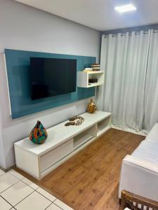 a living room with a flat screen tv on a wall at Marulhos Resort in Porto De Galinhas