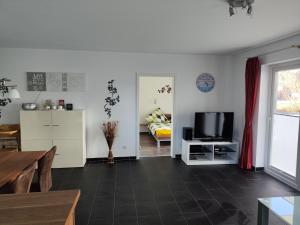 a living room with a tv and a couch at Nordsee Resort in Wangerland