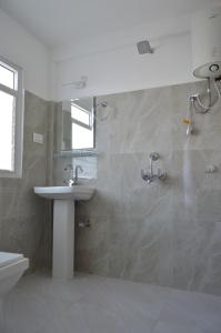 a bathroom with a sink and a mirror at Tenzin's Inn in Jālāpahār