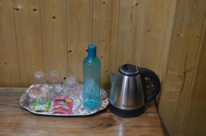 a table with a blue bottle and a tea kettle at Tenzin's Inn in Jālāpahār