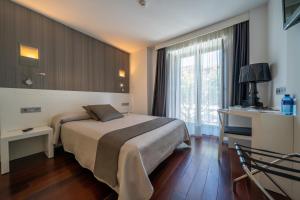 ein Hotelzimmer mit einem Bett und einem Fenster in der Unterkunft Hotel Apolonia Soria in Soria