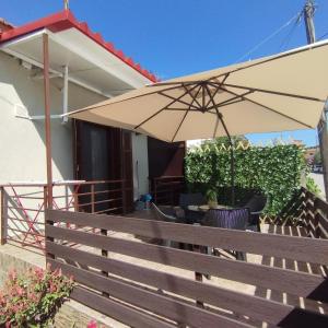 a patio with an umbrella and chairs and a table at Αίγλη Apartment in Ierissos