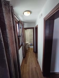 a hallway with a bathroom with a toilet and curtains at Αίγλη Apartment in Ierissos