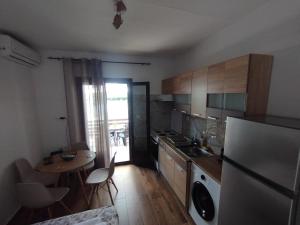 a small kitchen with a table and a refrigerator at Αίγλη Apartment in Ierissos +11 photos