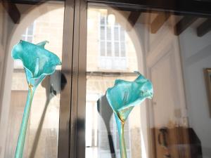 two blue glass flowers sitting in a window at s'Herència in Porreres