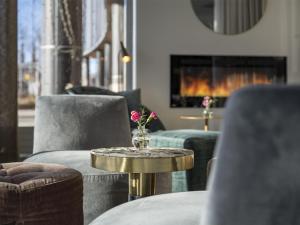 a living room with two chairs and a table with a vase on it at Radisson Blu Hotel Uppsala in Uppsala