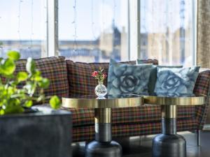 a living room with a couch and a vase on a table at Radisson Blu Hotel Uppsala in Uppsala
