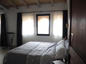 a bedroom with a bed and a window at s'Herència in Porreres