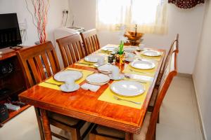 a dining room table with white dishes on it at Zeylon Villa Talalla in Matara