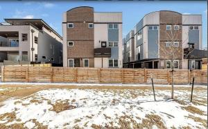 a wooden fence in front of some buildings at Spacious Denver Home with Private Rooftop Spa in Denver