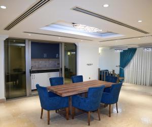 a dining room with a wooden table and blue chairs at Anbar International Hotel in Kumaysh