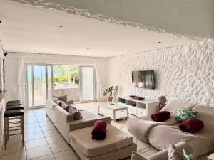 a living room with two couches and a tv at Aura Mar in Ponta do Ouro