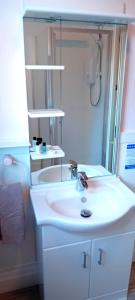 a white bathroom with a sink and a shower at Home and Away near the Spa in Bridlington +31 photos