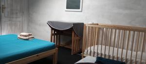 a room with a crib and a table and a bed at Quarto no Sótão in Coruche