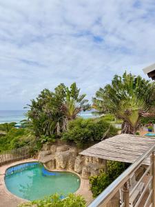 a view of a swimming pool and the ocean at Aura Mar in Ponta do Ouro