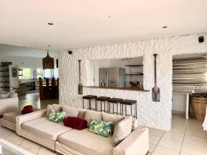 a living room with a couch and a kitchen at Aura Mar in Ponta do Ouro