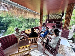 a group of people sitting in chairs on a porch at Goa Walet Cottage in Praya