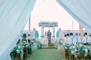 a bride and groom walking down the aisle at their wedding at Marinelli Beach Resort in San Agustin