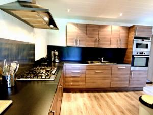 cocina con armarios de madera y horno con fogones en Charming Villa in La Roche en Ardenne, en Bertogne