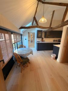 a dining room with a table and a kitchen at The stables at the Grange in York