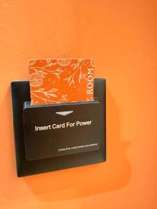 an insert card for a power box on an orange wall at Xhani Boutique Rooms in Durrës