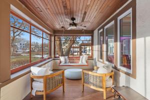 a screened in porch with chairs and a table at Featherstone in White Bear Lake