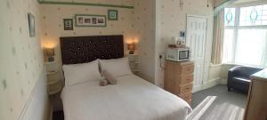 a bedroom with a large white bed and a microwave at Home and Away near the Spa in Bridlington