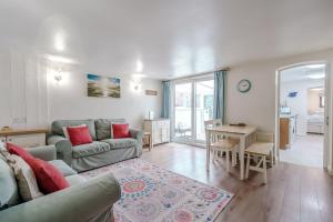 a living room with a couch and a table at Crossways Cottage, Dog-Friendly Cottage Near the Beach in Winterton-on-Sea