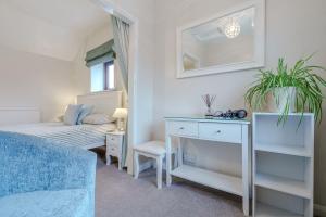 a bedroom with a bed and a desk and a mirror at Crossways Cottage, Dog-Friendly Cottage Near the Beach in Winterton-on-Sea