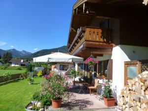 ein Haus mit einer Terrasse mit Stühlen und einem Sonnenschirm in der Unterkunft Blissful Apartment in Altenau with Patio in Altenau