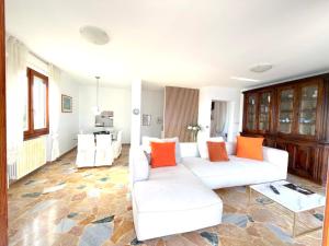 a living room with two white couches and orange pillows at White House in Cremia