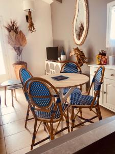 a dining room with a table and four chairs at Un cocon en Camargue in Saintes-Maries-de-la-Mer