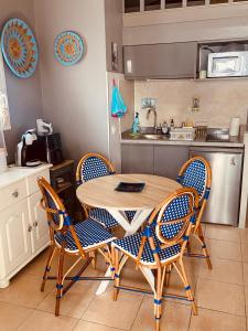 a kitchen with a wooden table and chairs at Un cocon en Camargue in Saintes-Maries-de-la-Mer +3 photos