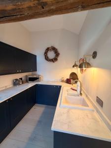a kitchen with blue cabinets and a sink at The stables at the Grange in York +10 photos